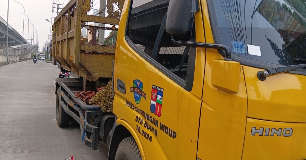 Truk pengangkut sampah DLH Kota Bogor bertuliskan TA 2024 terlihat berkarat dan terparkir di badan jalan.