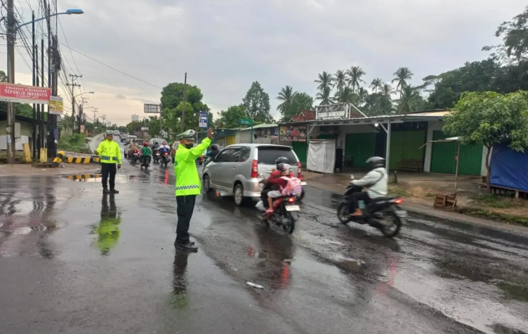Hujan Deras, Sat Lantas Polres Pesawaran Tetap Atur Lalu Lintas di Simpang Tugu Coklat